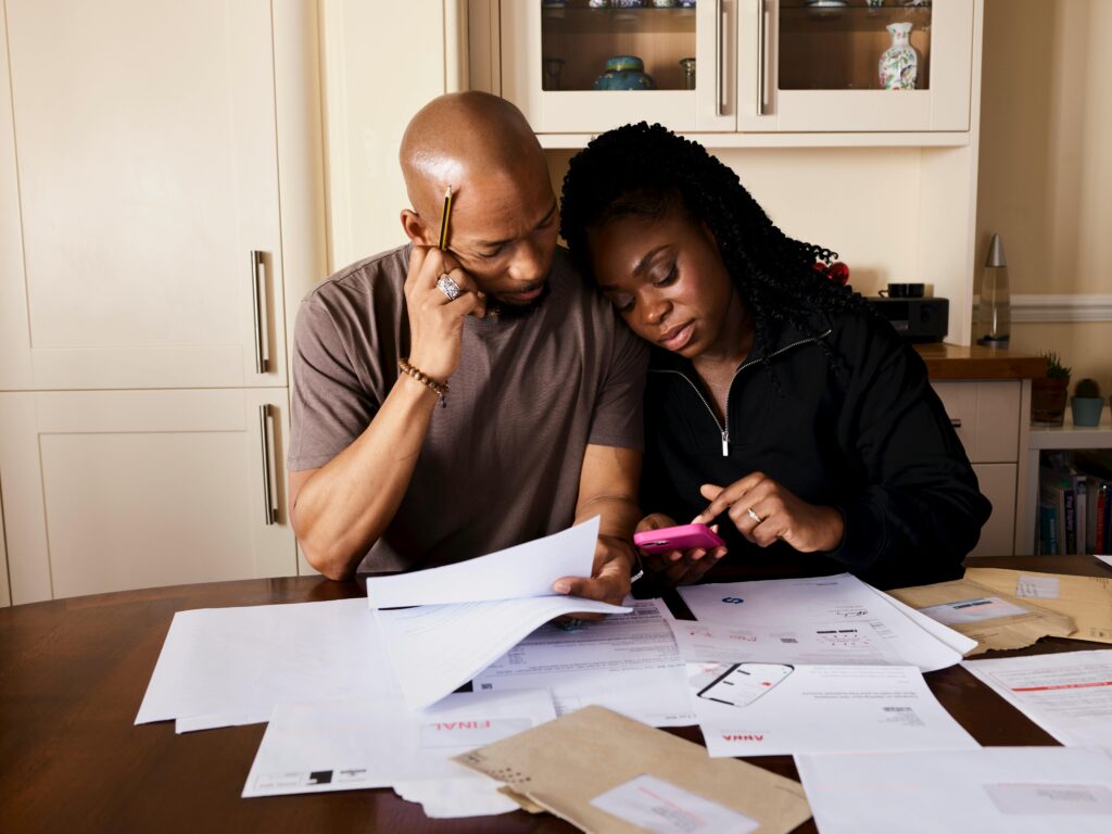 Couple Sitting by Table Calculating Expenses